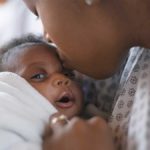 Mother kissing baby on forehead