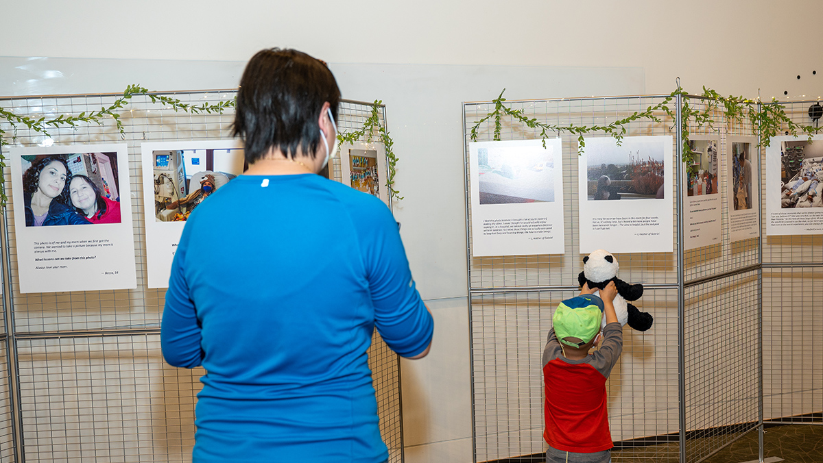 Mom and a boy showing panda toy to a photo