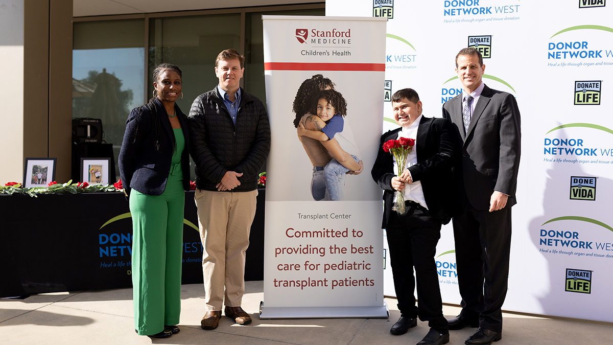 Joseph Sanchez-Munoz standing with his doctors in front of a sign