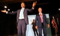 Richard Tice stands on stage with his arms outstretched next to Nigel Farage