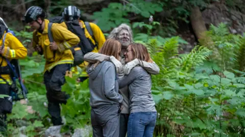 Photo of missing hiker hugging his family after he was found