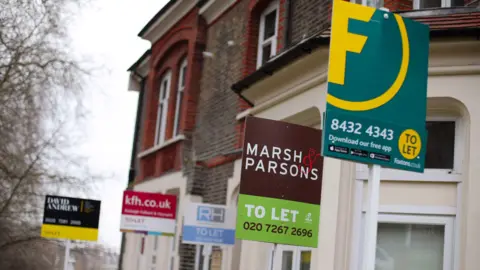 A row of 'to let' signs outside a house.