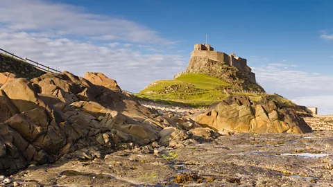Getty Images Lindisfarne Castle with rock pool in foreground