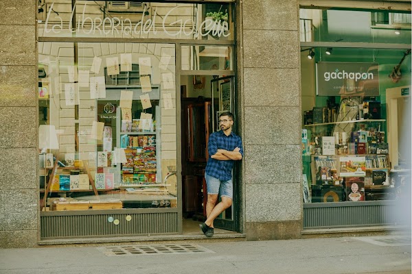Mattia leunt in gedachten tegen de deuropening van zijn winkel Libreria del Golem