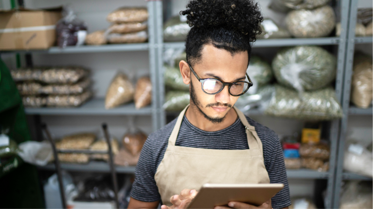 Een persoon gebruikt een tablet in het magazijn van een restaurant
