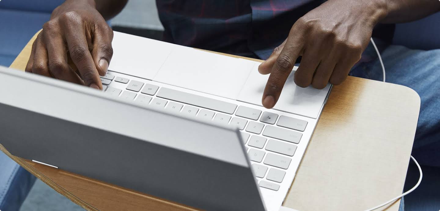 Handen die typen op het toetsenbord van een laptop.
