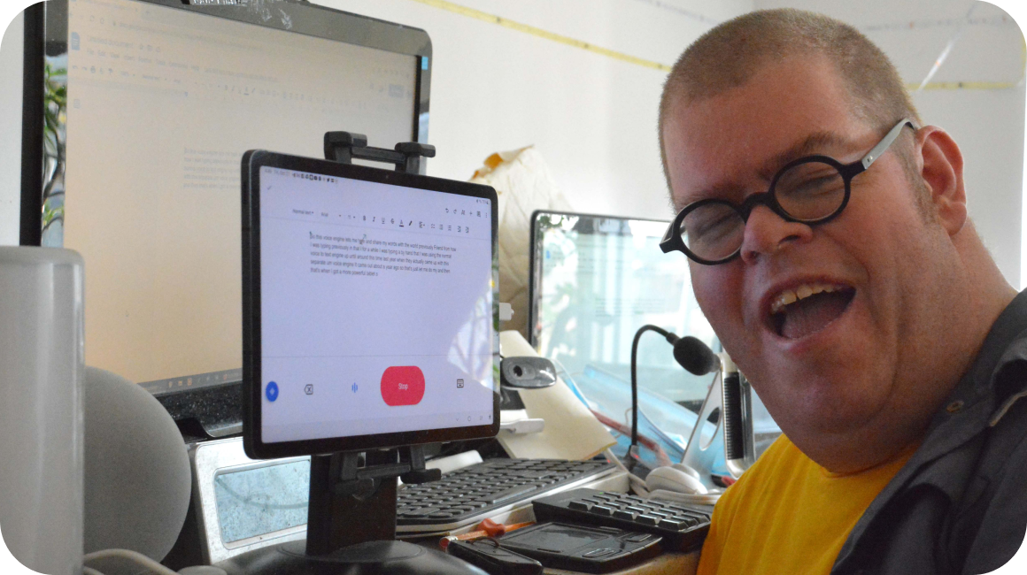 Adam smiling in front of a computer screen showing Project Relate