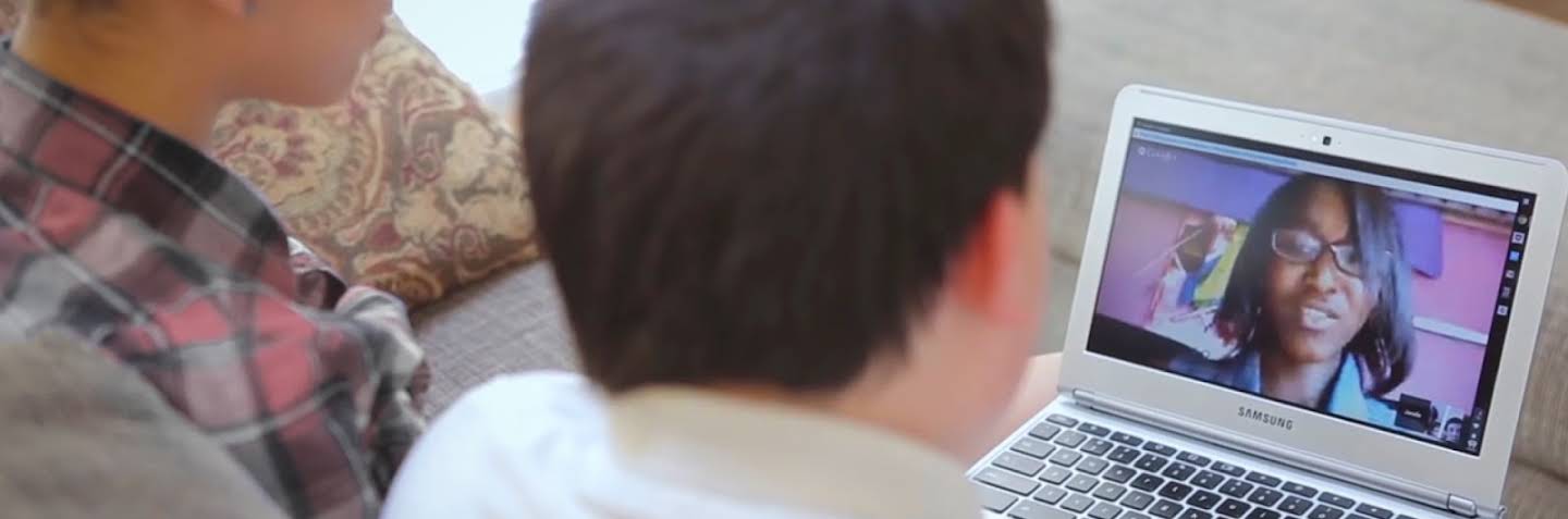 Two children staring at a laptop