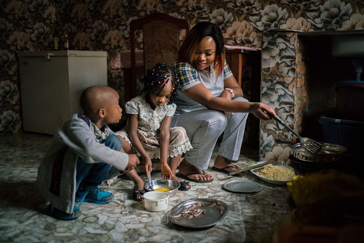 Riziki preparando el desayuno con dos de sus hijos
