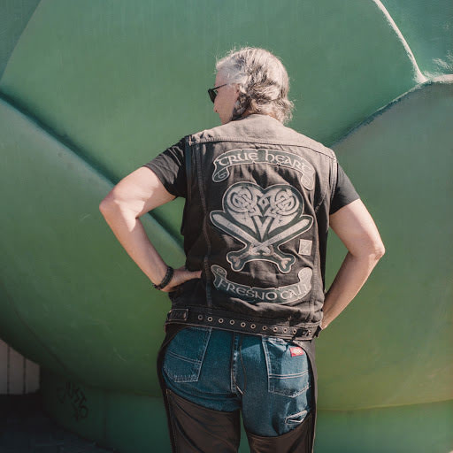 Woman motorcyclist showing off the back of her jacket.