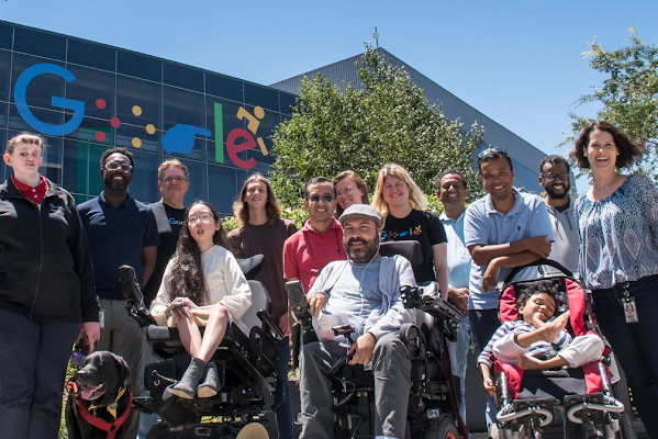 Miembros de Disability Alliance en Google frente a un edificio del campus con el logotipo de discapacidad de Google