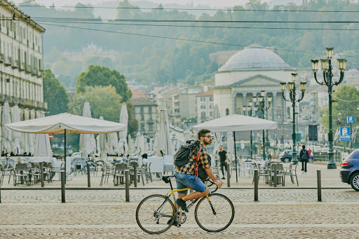 Mattia przemierza na rowerze brukowane uliczki Turynu