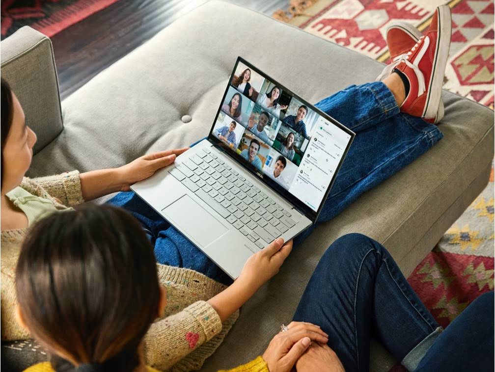 Duas mulheres sentadas em um sofá participando de uma reunião no Google Meet.