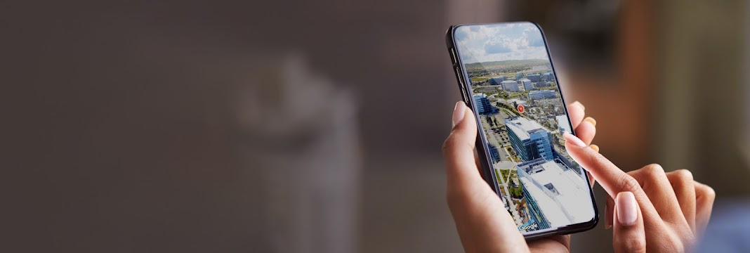 Mano sujetando un teléfono con vistas de una ciudad en 3D