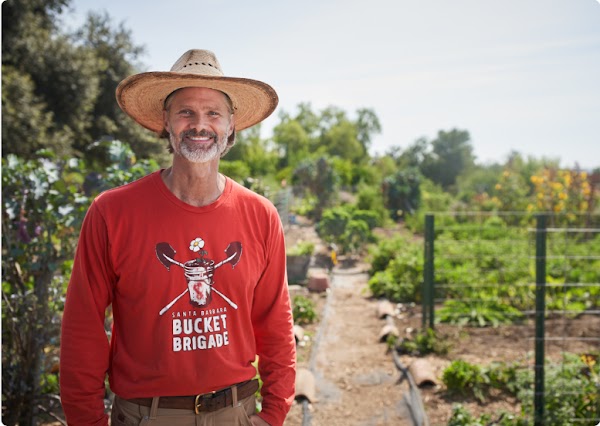 Abe in front of a community garden that is part of the Growing Community Project.
