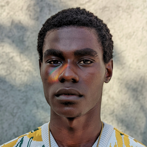 Portrait of a dark-skinned Black man with gentle colorful light adorning his face