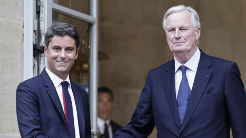 Newly appointed Prime Minister Michel Barnier (R) shakes hands with outgoing prime minister Gabriel Attal (L) during the handover ceremony at the Hotel Matignon in Paris, on September 5, 2024.