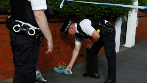 A police officer places flowers, given by residents, behind the police cordon near the scene of a stabbing incident in Southport, Britain, July 29, 2024.