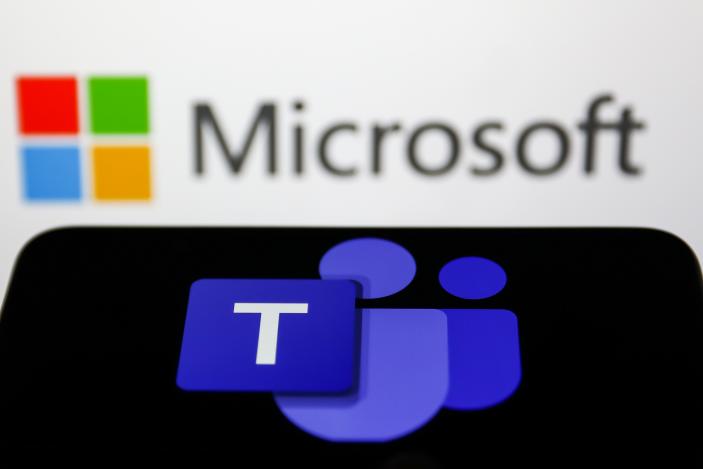 Microsoft Teams logo displayed on a phone screen and Microsoft logo displayed on a screen in the background are seen in this illustration photo taken in Krakow, Poland on May 26, 2022. (Photo Illustration by Jakub Porzycki/NurPhoto via Getty Images)