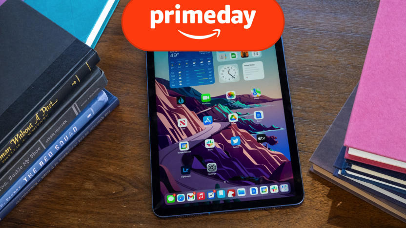 The 5th generation ipad air is on a wooden table with books nearby. the orange prime day logo is on top. 