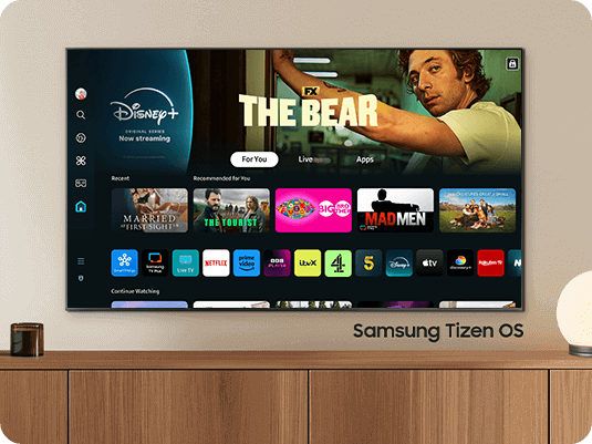 The 2024 Samsung OLED TV displays various free channels and streaming content on the Samsung Tizen OS home screen.